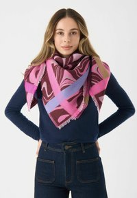 Écharpe multicolore présentant des motifs géométriques en rose, bourgogne et lavande. Fabriquée en tissu texturé avec des bords à franges.