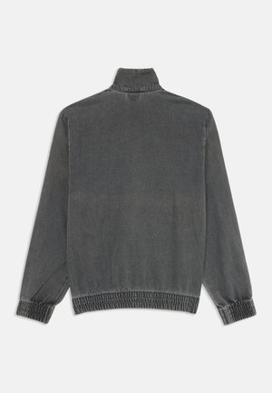 Sivi lagani kaput s visokim ovratnikom, dugim rukavima i elastičnim manžetama i rubom. Meki, teksturirani materijal s suptilnim sjajem.