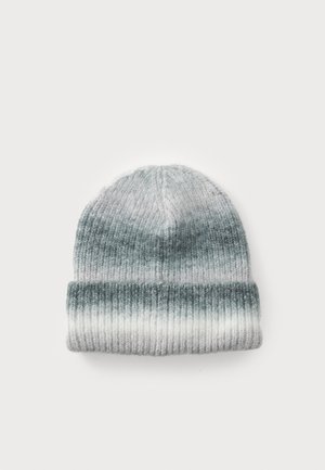 Knit beanie dalam gradasi warna abu-abu dan putih, dengan tekstur ribbed dan cuff terlipat untuk tambahan kehangatan dan gaya.