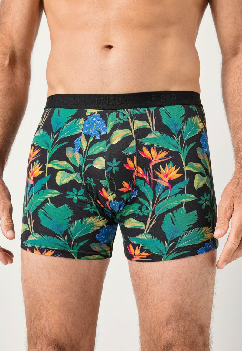 Bavlněné trenýrky s černým pozadím a výraznými tropickými květinovými vzory v zelené, modré a oranžové barvě. Elastický pás s logem.