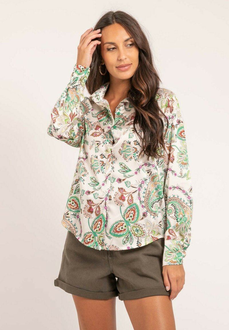 Chemise à manches longues, boutonnée, de couleur blanche avec un imprimé paisley coloré en verts, rouges et bruns. Tissu doux, coupe décontractée, ourlet arrondi.