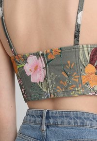 Bloemendessint crop top met groene stof en meerkleurige bloemen, gestructureerd ontwerp en verstelbare dunne bandjes.