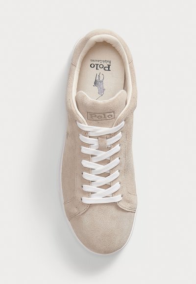 Baskets en suède beige de Polo Ralph Lauren avec des lacets blancs et un logo sur la languette rembourrée et la semelle intérieure, vues de dessus sur un fond blanc.