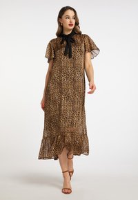 Rochie cu imprimeu leopardeau, cu manșete scurte transparente, un fundiță neagră la gât și un tiv cu volane stratificate, fabricată din material ușor.