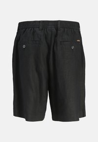 Schwarze Leinen-Shorts mit einem elastischen Taillenbund, zwei hinteren Taschen mit Knöpfen, Seitentaschen und einer lockeren Passform. Subtile Textur sichtbar.