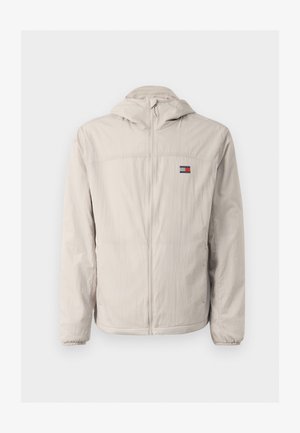 Heledbeez värvi lukuga tuulejakk kapuutsiga, elastsete mansettidega, küljetaskutega ning väikese Tommy Jeans logo'ga rinna peal.