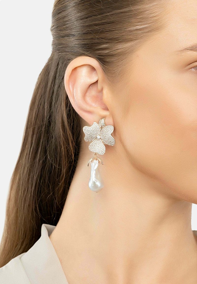 Gold-tone earrings designed as flowers, featuring sparkling crystals and a drop-shaped pearl accent. Textured petals provide visual interest.