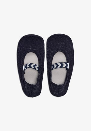 Une paire de chaussons pour enfants bleu sombre avec des semelles grises et des sangles bleu marine ornées de motifs en chevrons blancs.