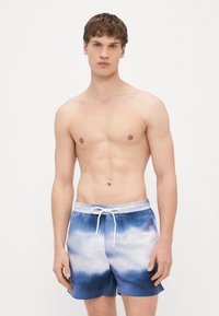 Mėlyni ir balti tie-dye stiliaus plaukimo šortai su elastine juosmens dalimi ir raišteliais. Pagaminti iš lengvos medžiagos, su lygiu paviršiumi.