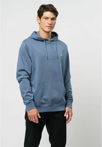 Kapuca sweatshirt v temno modri mešanici bombaža z sprednjim žepom, nastavljivimi vezalkami in majhnim logotipom na prsih. Dolgi rokavi in rebrasti robovi.