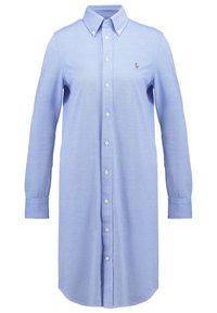 Helles blaues Hemd mit langen Ärmeln, Kragen und geradem Saum. Mit weißen Knöpfen und einem kleinen Logo auf der Brust. Der Stoff hat eine glatte Textur.