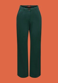 Tmavě zelené široké nohavice mají knoflíkový uzávěr, dvě přední kapsy a hladkou texturu na jednobarevném oranžovém pozadí.