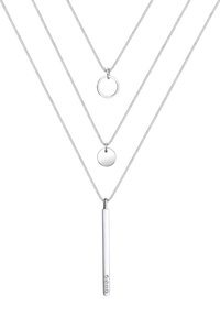 Tre sølvhalskæder lagdelt sammen; en har en lodret stangpendant med fem små sten, en anden har en cirkulær pendant, og den sidste er en ring.