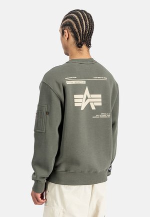 Sudadera verde oliva con cuello redondo, tejido texturizado, detalle gráfico en la parte trasera en color crema y bolsillo en la manga izquierda.