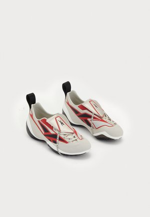 Climbing shoes with a white and red design, featuring a slip-on structure, rubber outsole, and a distinctive overlay pattern.