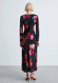 Rochie lungă neagră cu un model floral în roz, roșu și teal. Textură netedă, cu o siluetă ajustată și lungime până la gleznă.