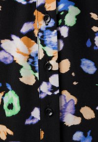 Lilledega riie mustal taustal, kus on sinised, rohelised, oranžid ja valged lilled. Keskosas viis musta nuppu.