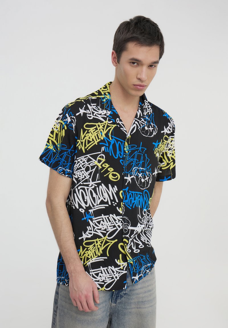 Camicia a maniche corte con bottoni di colore nero, decorata con motivi in stile graffiti colorati in blu, giallo e bianco. Vestibilità casual con una texture morbida.