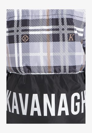 Gesteppten Jacke mit einem grau-schwarz-weißen Karomuster, akzentuiert mit goldenen Details und einem schwarzen Unterteil, auf dem "KAVANAGH" in großen weißen Buchstaben steht.