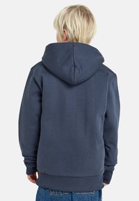 Felpa con cappuccio blu navy, dotata di tasca a marsupio, polsini e orlo a costine. Realizzata in un tessuto morbido e dalla texture liscia.