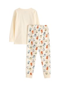 Pyjama-Set mit langärmeligem cremefarbenem Oberteil und cremefarbenen Hosen, die bunte Hundemuster aufweisen. Hergestellt aus weichem Baumwollmaterial mit elastischem Bund.