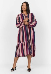 Robe longue rayée dans des teintes de rose, bleu marine et moutarde. Dispose d'un ourlet à volants froncés et de longues manches avec des accents de boutons.