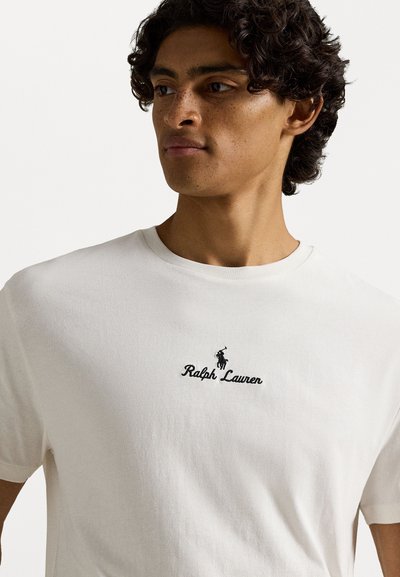 Λευκό βαμβακερό μπλουζάκι με στρογγυλή λαιμόκοψη, κοντά μανίκια και μαύρο κεντημένο λογότυπο "Ralph Lauren" με γραφικό παίκτη polo.