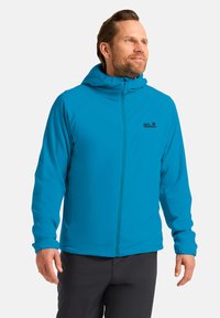 Giacca blu con zip e cappuccio, realizzata in tessuto leggero e con logo sul lato sinistro del petto. Le maniche sono aderenti e il design è slanciato.