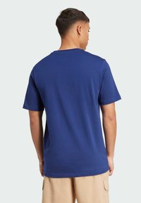 Marineblå kortærmet T-shirt lavet af bomuld, med en klassisk rund halsudskæring og en glat tekstur, der viser et minimalistisk design.