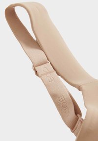 Cinghia di reggiseno beige con texture liscia, hardware regolabile, con testo in rilievo "BODY" sulla cinghia e design senza cuciture.