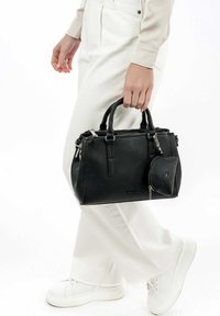 Svart grus läderhandväska med dubbla handtag, dragkedjestängning och en avtagbar rund myntpung. Utrustad med silverfärgad hårdvara och rektangulär form.