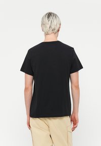Black short-sleeve t-shirt with a crew neck. Smooth cotton material, casual fit. Minimalistic design with no visible patterns or graphics.