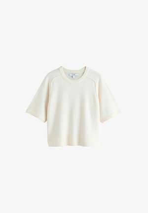 Kremowy sweter z krótkim rękawem, wykonany na drutach. Posiada okrągły dekolt, rękawy raglanowe oraz ściągacze na mankietach i dole. Miękka, teksturowana tkanina.