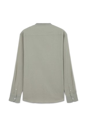 Chemise à manches longues en tissu vert clair, dotée d'un ourlet arrondi, de poignets boutonnés et d'un empiècement dos pour la structure. Texture lisse.