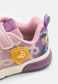 Baskets pour enfants roses avec une tige en mesh respirant, des accents scintillants, un design graphique sur le côté et une embellissement sur le thème d'un smiley jaune.