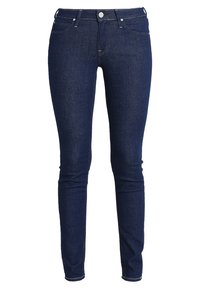 Štíhlé džíny ve tmavě indigo denim, s klasickým pětipocket designem, stříbrným kováním a tónovým prošíváním po celém modelu.