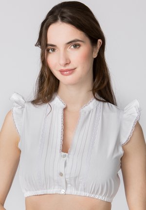 Weiße kurz geschnittene Bluse mit voluminösen Ärmeln, verziert mit Spitzenbesatz, Knopfverschluss und vertikalen Streifen auf einem glatten Stoff.