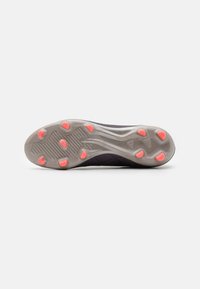 Suela de zapatilla de correr con un fondo texturizado en gris y acentos de goma de color rosa brillante. El diseño incluye un patrón único y ranuras para tracción.