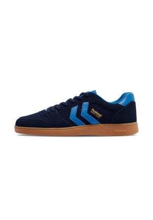 Dark blue low-top sneaker with blue chevron stripes, brown sole, and "hummel" logo on the side.