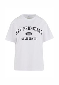 Balta kokvilnas T-kreklu ar īsām piedurknēm, ar melnu tekstu: "SAN FRANCISCO 2000 CALIFORNIA" izteiksmīgā, lielo burtiem rakstītā fontā.