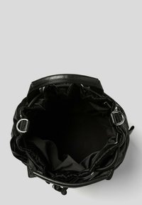 Czarna skórzana torba typu bucket z miękkim, marszczonym wierzchem, srebrnymi elementami oraz przestronnym, niepodszewkowanym wnętrzem.