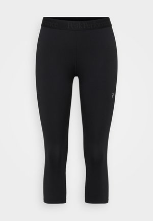 Leggings capri noirs en tissu extensible avec une texture douce, dotés d'une large ceinture élastique et d'un détail logo sur la jambe inférieure.