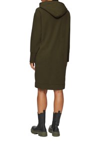 Olijfgroene hoodie jurk met een kangoeroezak, geribde manchetten en zoom. Gecombineerd met zwarte enkellaarsjes met een chunky zool.