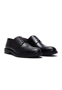Zwarte leren dresschoenen met een gladde textuur, ronde neus en vetersluiting. Beschikt over een lage gestapelde hak en een duurzame rubberen zool.