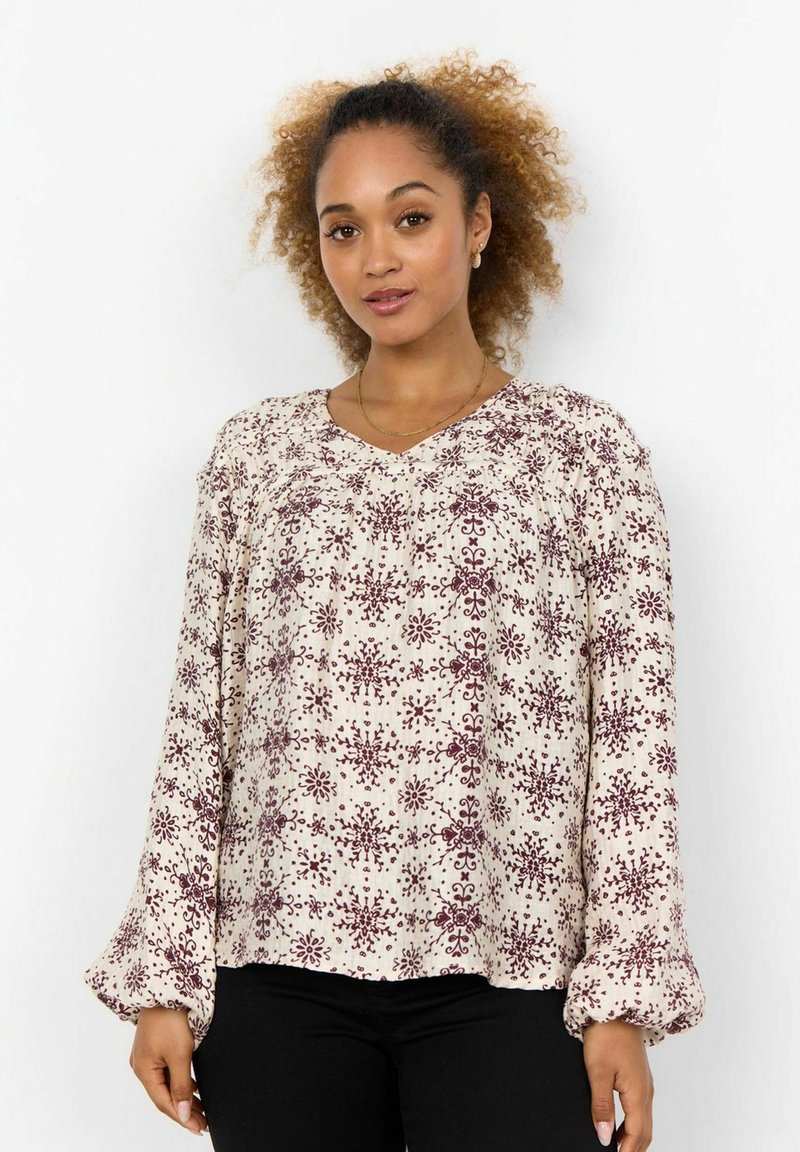 Långärmad blus i kräm med ett vinrött blommönster, med V-ringning och texturerade ärmar. Tillverkad av lättviktig tyg.