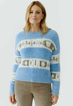 Hellblauer, flauschiger Pullover mit weißen und braunen horizontalen Streifen, die abstrakte Muster zeigen. Gerippte Bündchen und Rundhalsausschnitt.