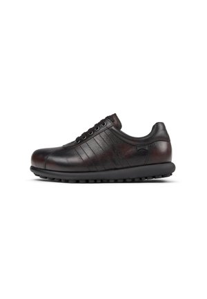 Black leather sneaker with textured sides, six eyelets, rounded toe, and a rubber sole featuring small circular grips.