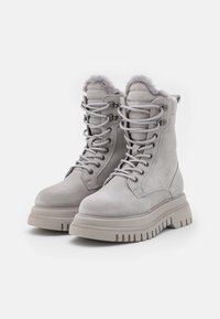 Gray suede lace-up boots with a chunky rubber sole, padded collar, and faux fur trim at the top. Features metal eyelets and textured surface.