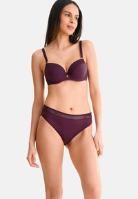 Ensemble de lingerie bourgogne comprenant un soutien-gorge rembourré avec armatures et des accents de dentelle géométrique, accompagné de culottes taille haute assorties avec une bande décorative.