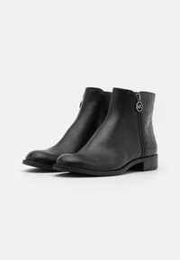 Bottines en cuir noir avec une finition lisse, une fermeture éclair sur le côté et un panneau à motif crocodile texturé au niveau du talon. Talon bas en bloc.